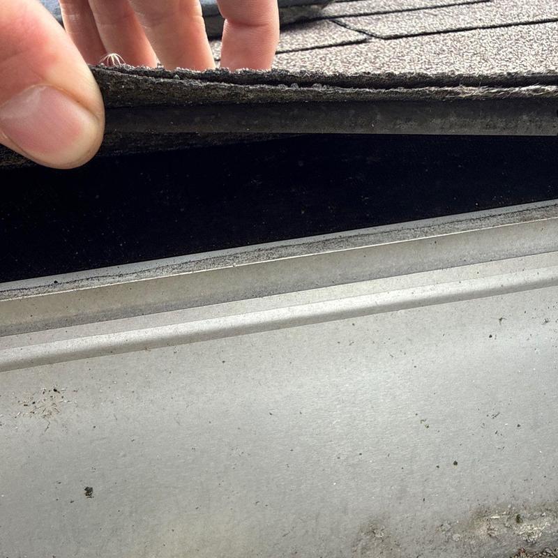 Roof shingles lifted to inspect metal flashing condition