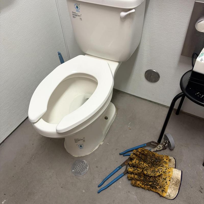 Toilet plumbing with drain snaking tools and gloves