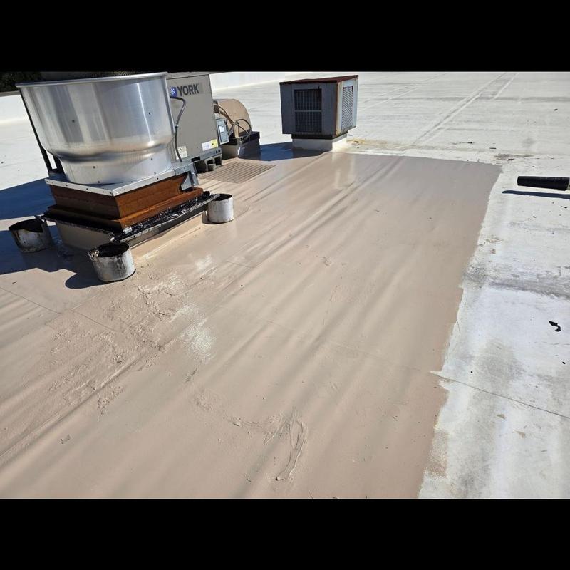 Silicone roof coating applied around HVAC unit on commercial roof Silicone roof coating applied around HVAC unit on commercial roof