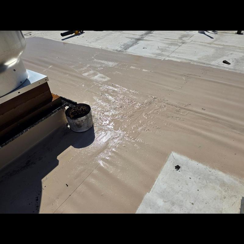 Silicone roof coating applied on commercial building roof Silicone roof coating applied on commercial building roof