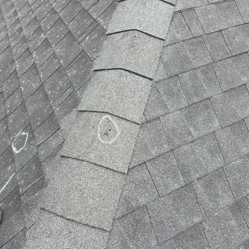 Asphalt roof shingles with hail damage markings Asphalt roof shingles with hail damage markings