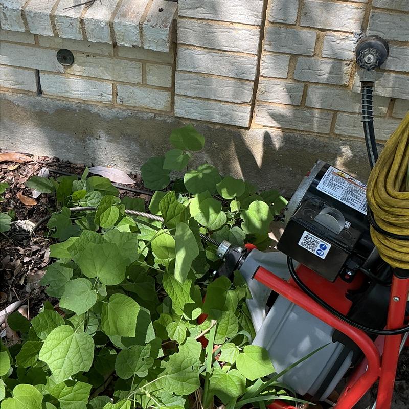 Cleanout pipe with drain machine clearing stoppage outdoors