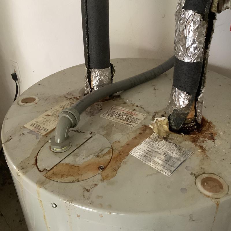 Electric water heater with rust and pipe insulation damage Electric water heater with rust and pipe insulation damage
