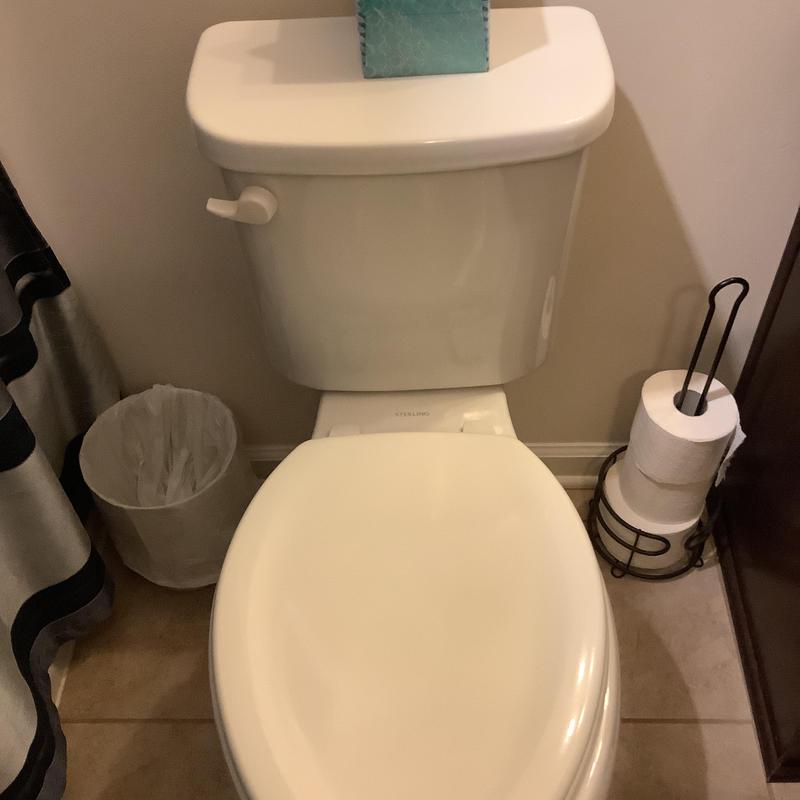 Sterling toilet with closed lid in bathroom corner Sterling toilet with closed lid in bathroom corner