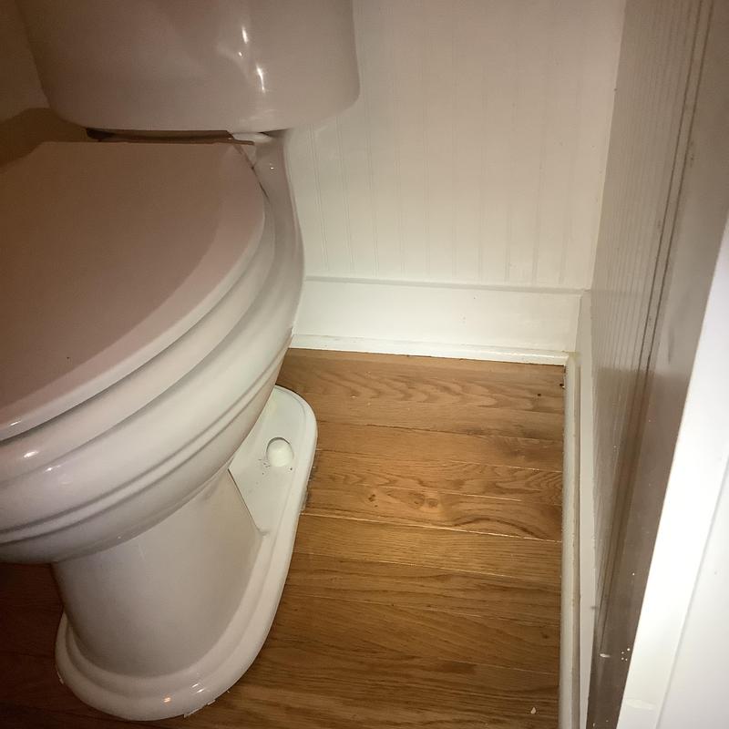 Toilet with new bolts and supply line on wood floor Toilet with new bolts and supply line on wood floor