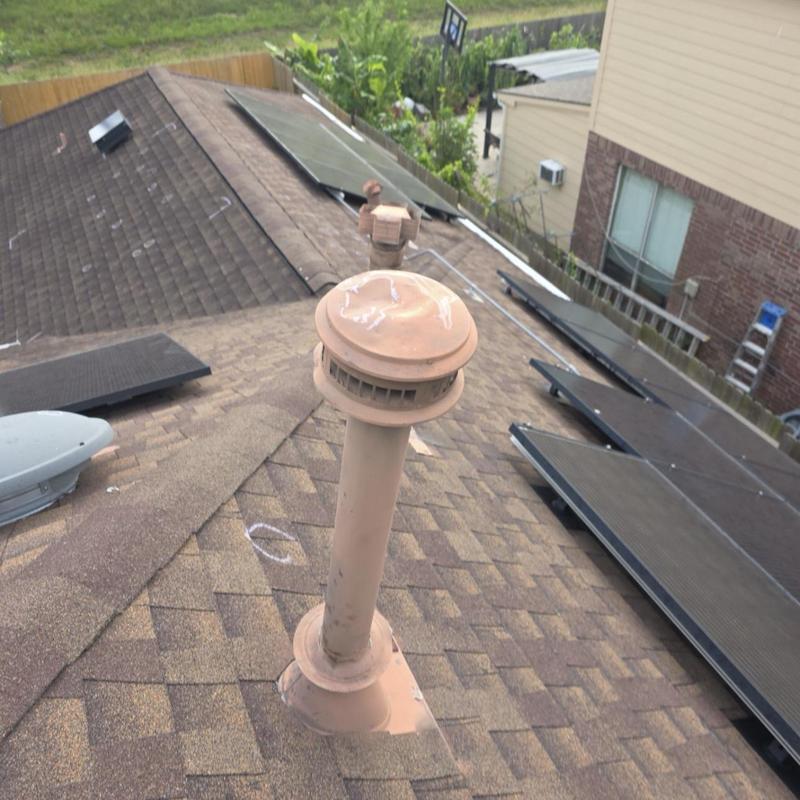 Roof vent pipe on shingle roof with solar panels Roof vent pipe on shingle roof with solar panels