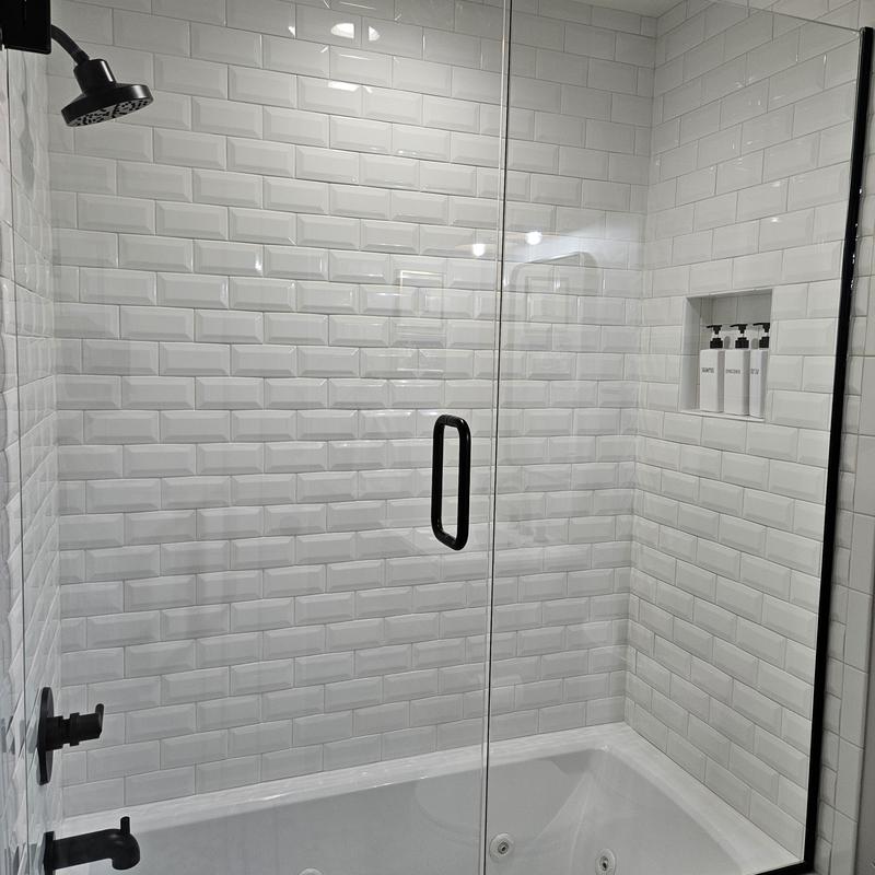 Shower enclosure with black fixtures and white subway tiles Shower enclosure with black fixtures and white subway tiles