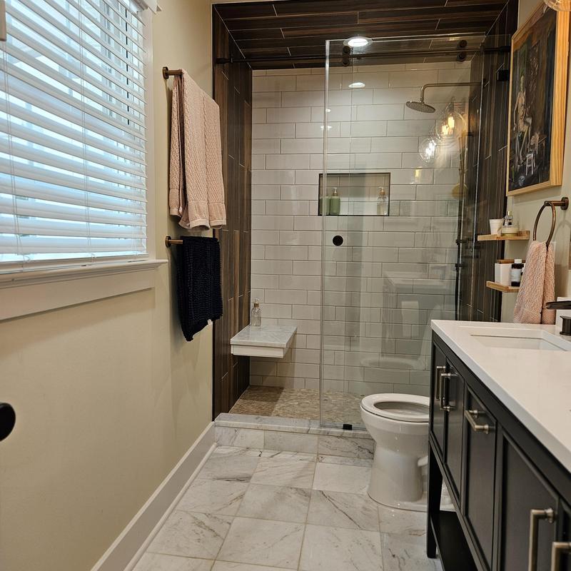 Glass shower enclosure with tile walls and marble floor Glass shower enclosure with tile walls and marble floor