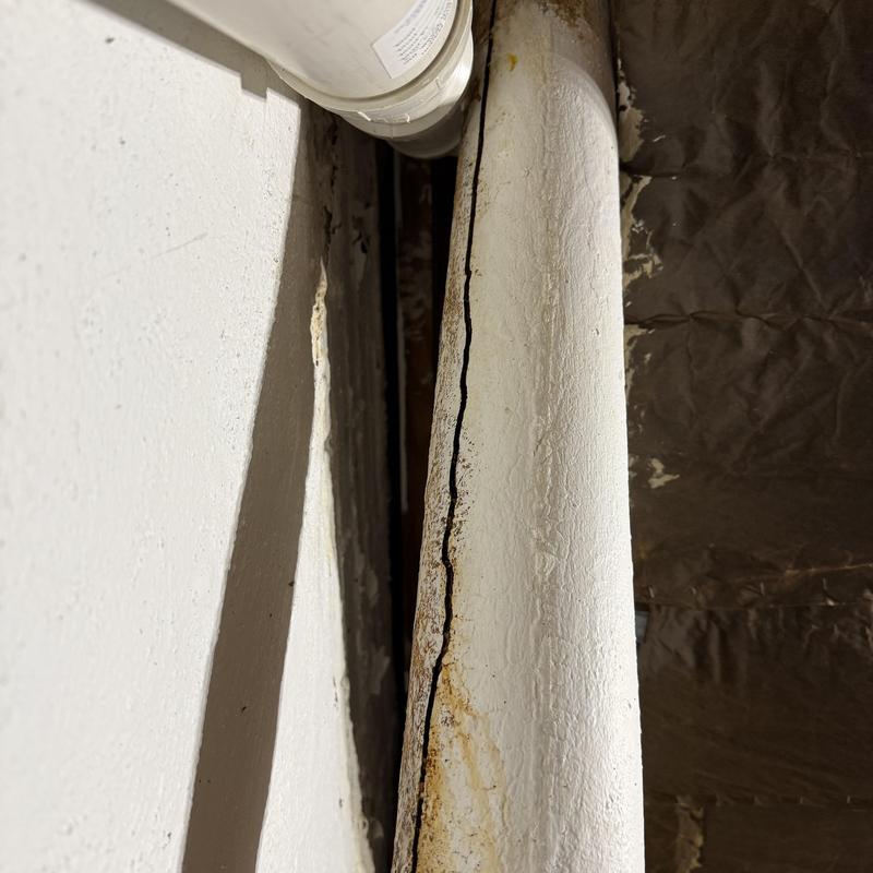 Cracked cast iron drain pipe in basement wall gap Cracked cast iron drain pipe in basement wall gap