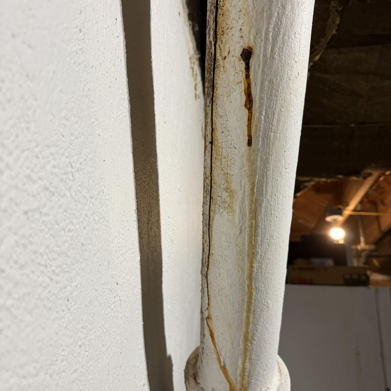 Cracked basement drain pipe with rust and corrosion Cracked basement drain pipe with rust and corrosion