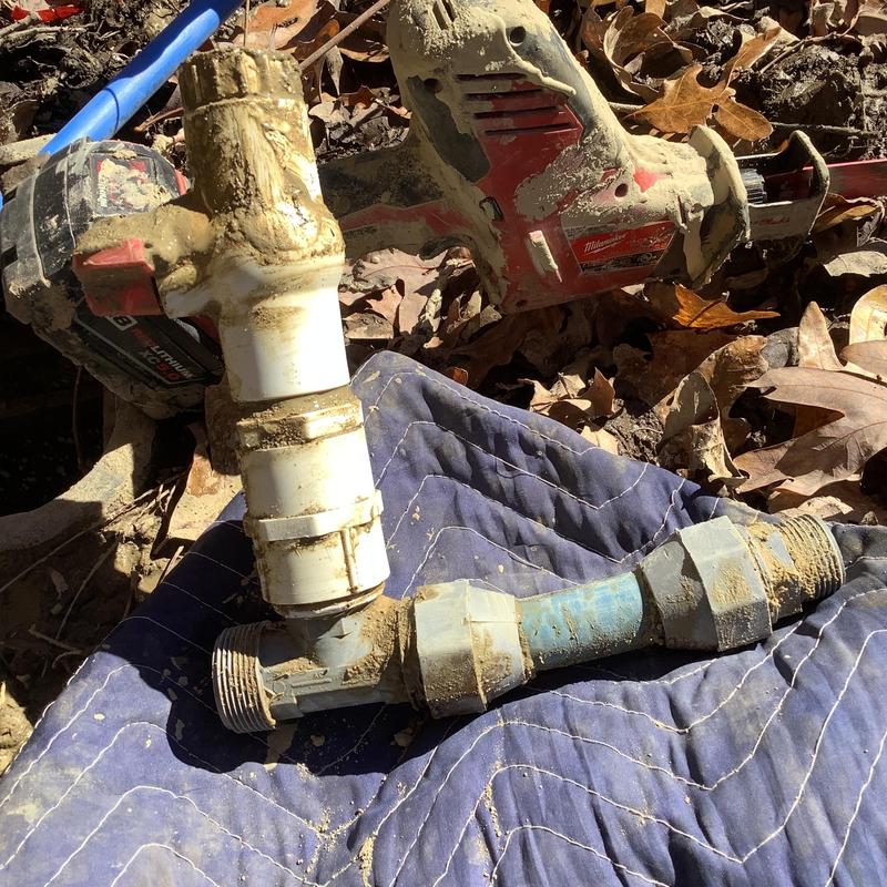 Main waterline pipe and valve with tools on ground Main waterline pipe and valve with tools on ground