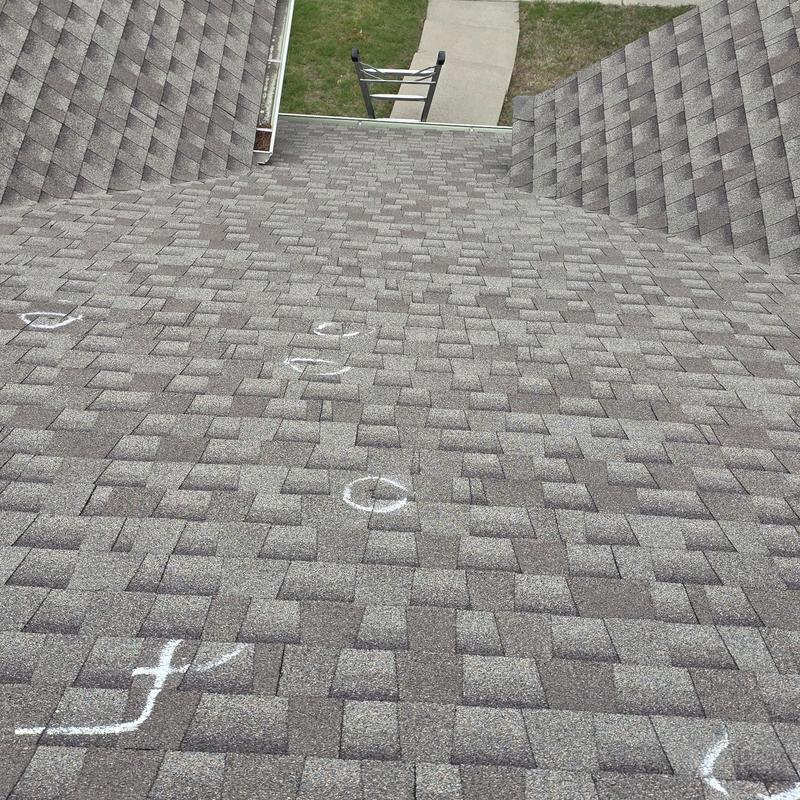 Asphalt shingle roof with hail damage marked in chalk