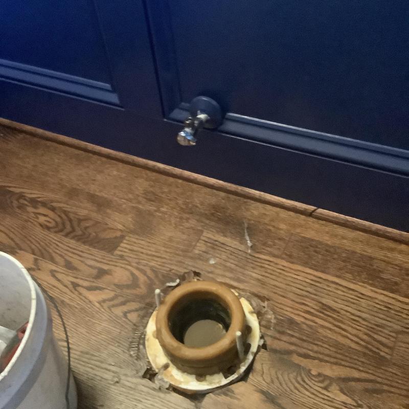 Toilet flange on hardwood floor with valve nearby Toilet flange on hardwood floor with valve nearby