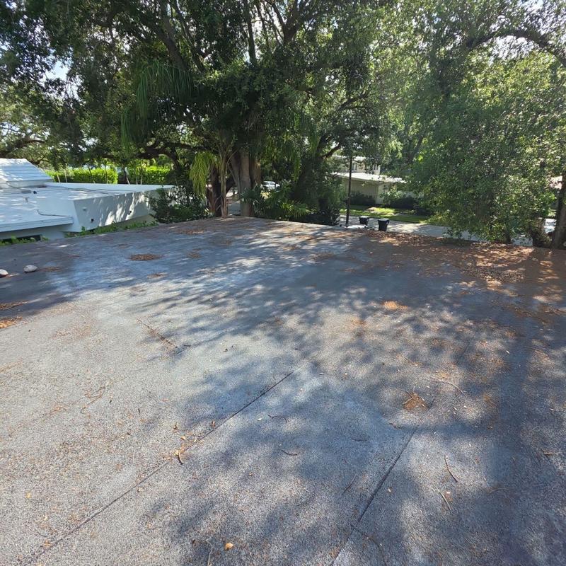 Flat roof surface with debris and tree shadows