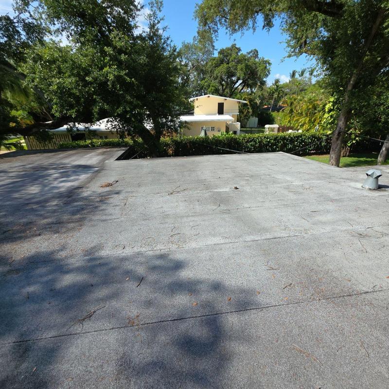 Flat roof surface with ventilation pipe and trees
