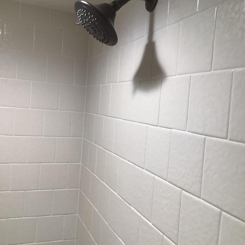 Delta bronze shower faucet with white tile walls Delta bronze shower faucet with white tile walls