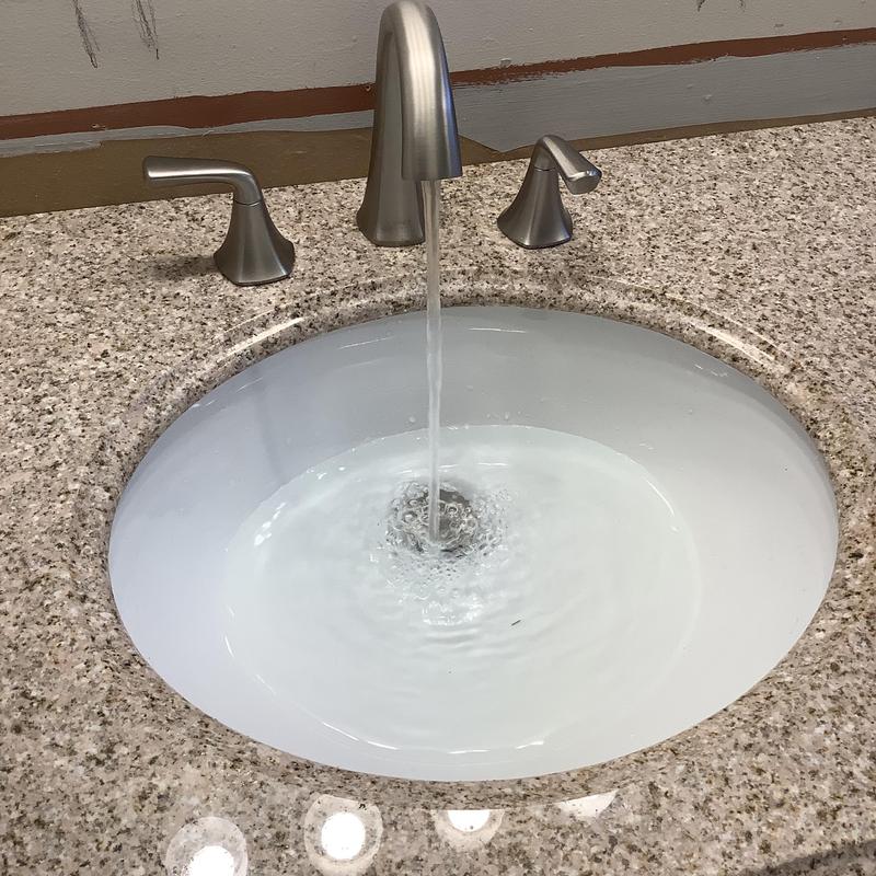 Vanity sink with running faucet on granite countertop Vanity sink with running faucet on granite countertop