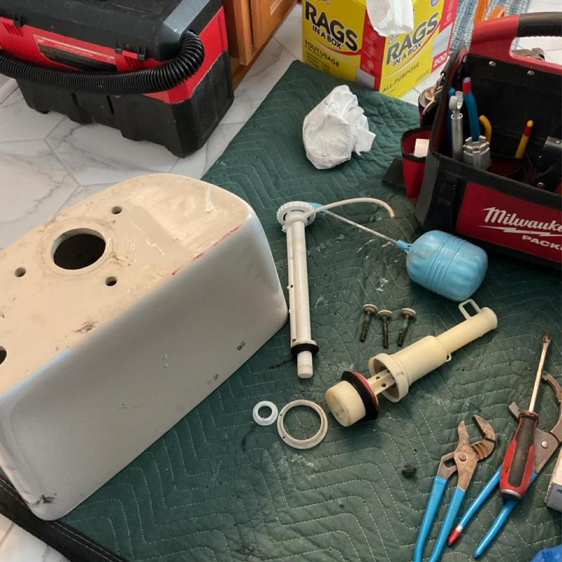 Toilet tank and flush valve parts with plumbing tools Toilet tank and flush valve parts with plumbing tools