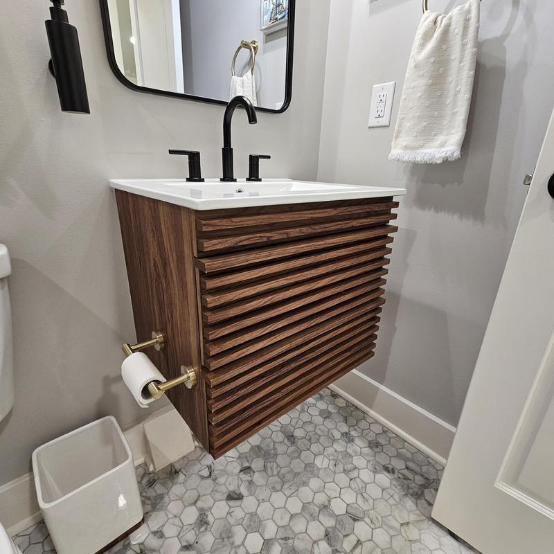 Floating wooden vanity with black faucet and hex tile floor Floating wooden vanity with black faucet and hex tile floor