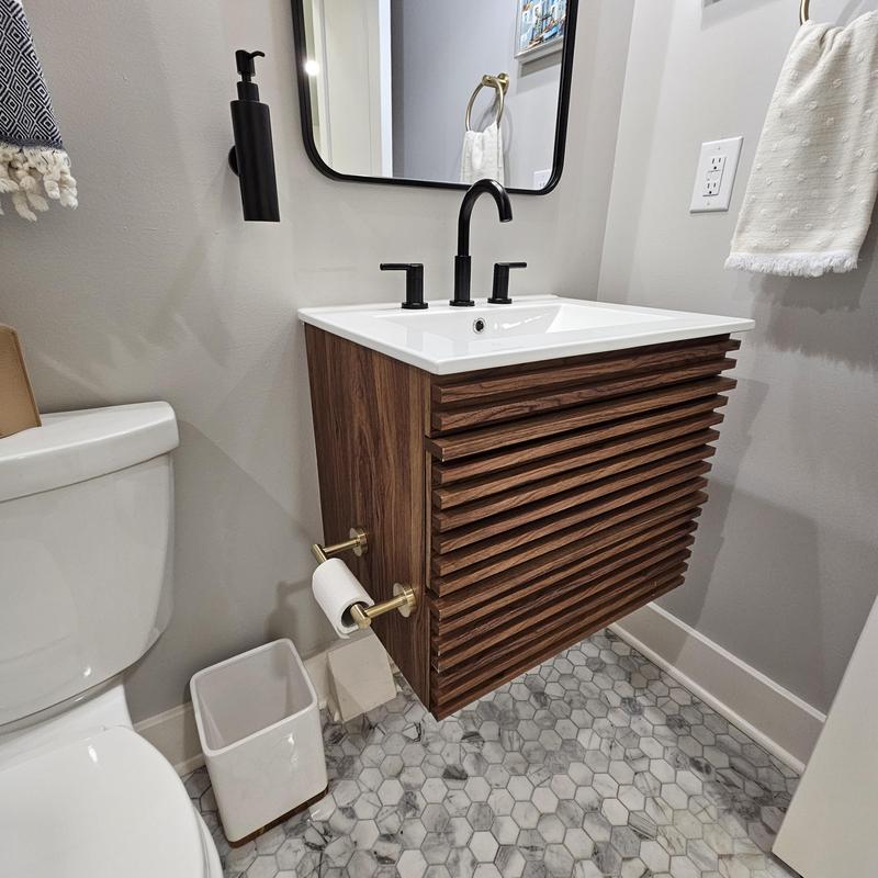 Floating wood vanity with black faucet and hex tile floor Floating wood vanity with black faucet and hex tile floor