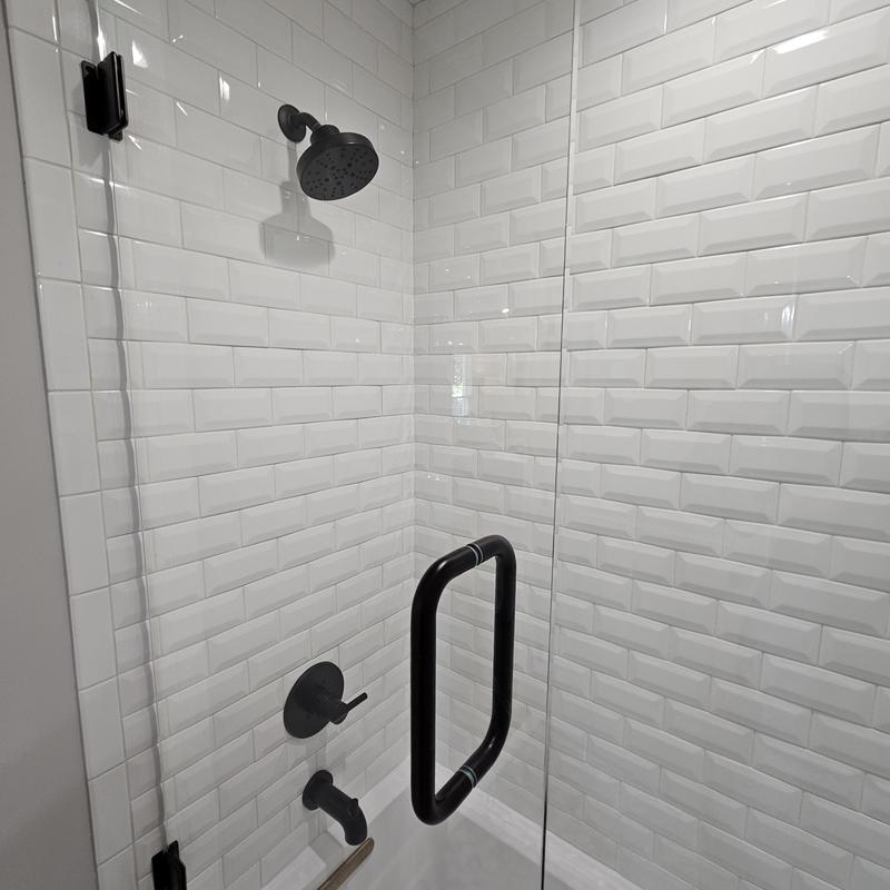 Shower enclosure with black fixtures and white tile Shower enclosure with black fixtures and white tile
