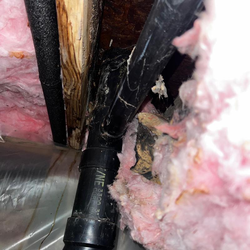 PVC drain pipe with pink insulation in attic space PVC drain pipe with pink insulation in attic space