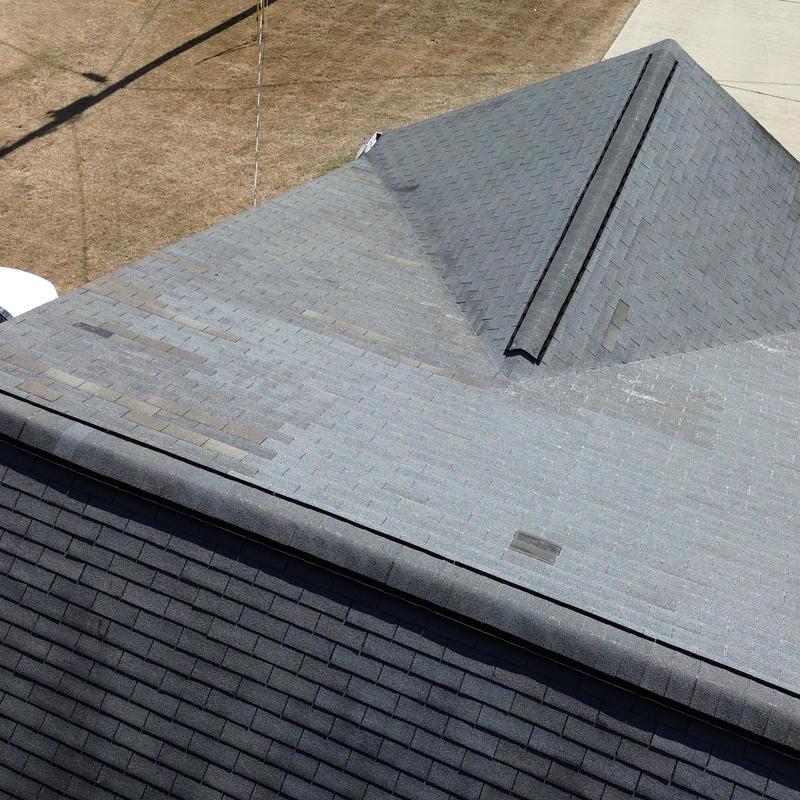 Shingle roof with worn and damaged areas visible Shingle roof with worn and damaged areas visible