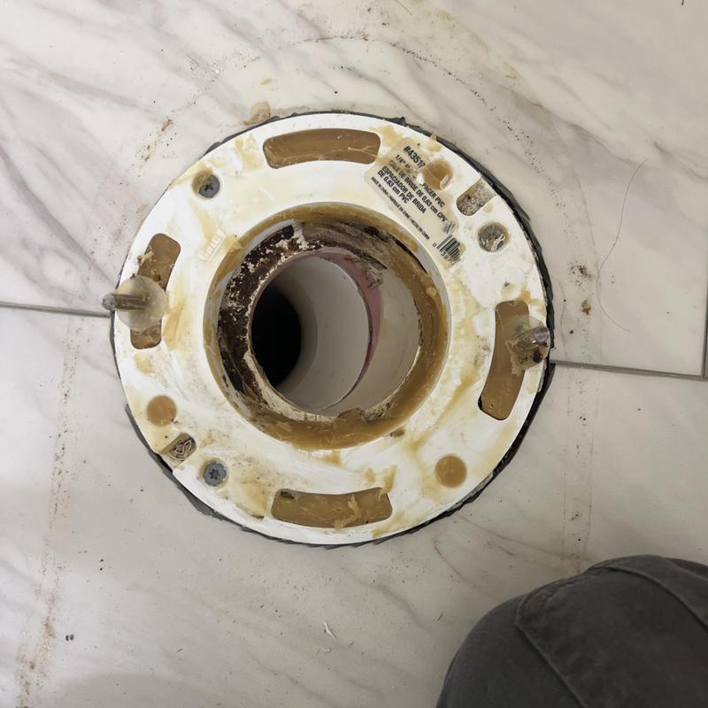 Toilet flange installation on tile floor in home bathroom Toilet flange installation on tile floor in home bathroom