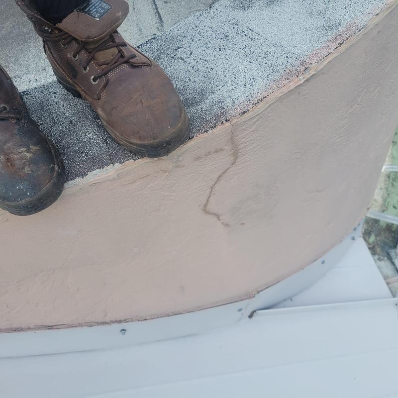 Concrete tile roof edge with visible crack and roofing boots