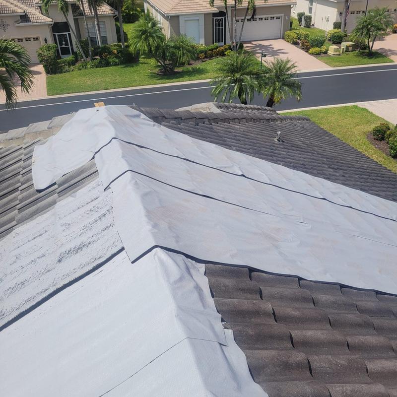 Concrete tile roof covered with temporary tarp for leak protection