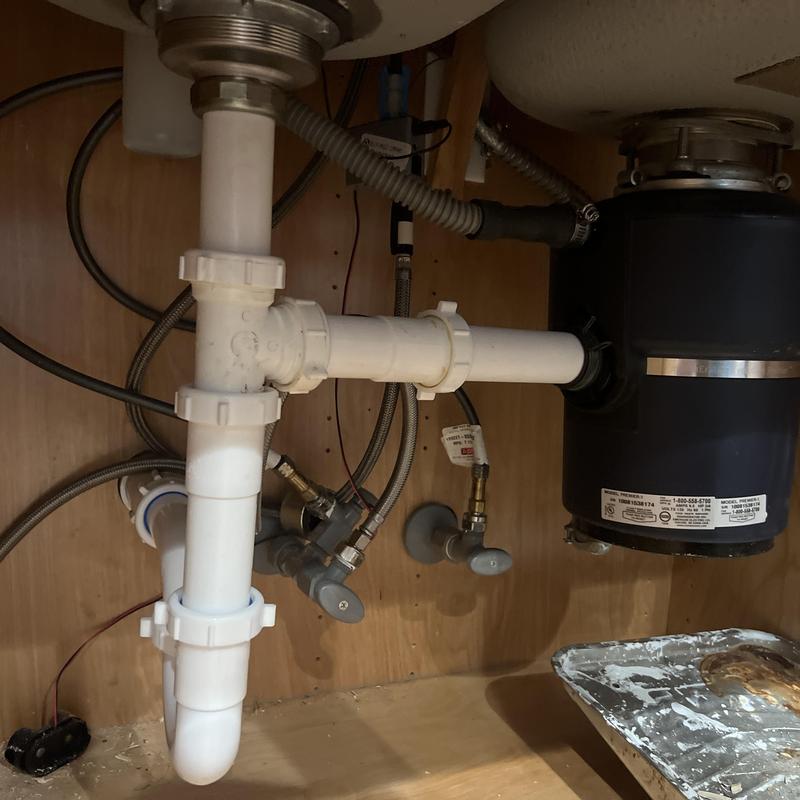 Garbage disposal and PVC drain pipes under sink