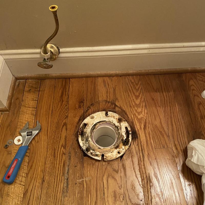 Toilet flange on hardwood floor with wrench and washers Toilet flange on hardwood floor with wrench and washers