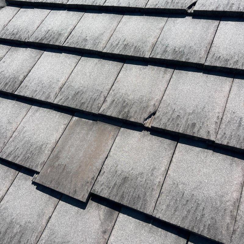Concrete tile roof with damaged and faded tiles Concrete tile roof with damaged and faded tiles