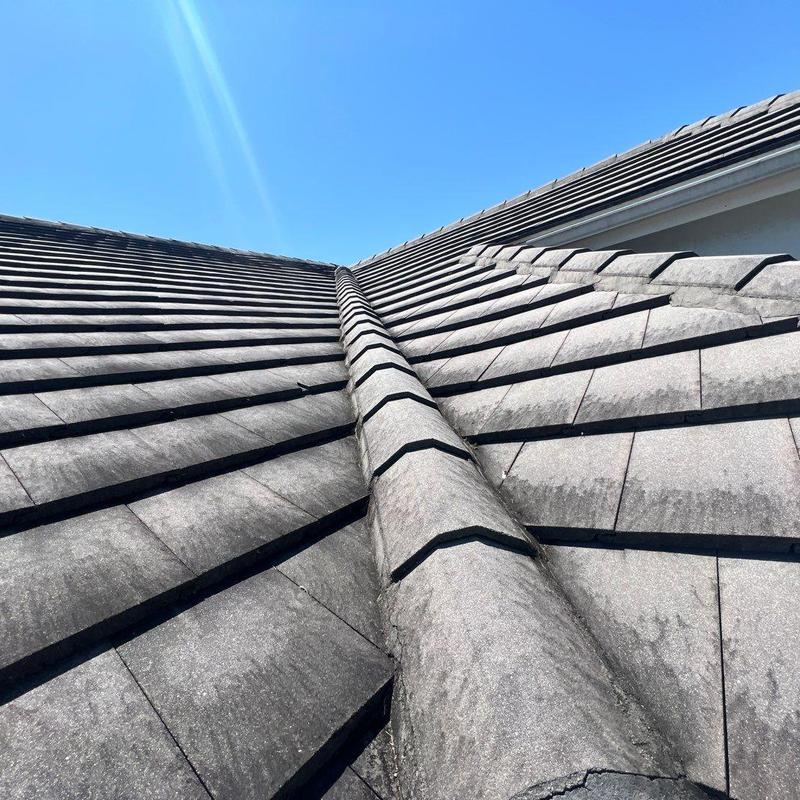 Concrete tile roof ridge with weathered tiles under sun Concrete tile roof ridge with weathered tiles under sun