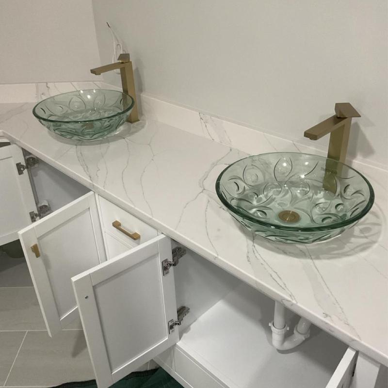 Glass vessel sinks with gold faucets and open cabinet doors Glass vessel sinks with gold faucets and open cabinet doors