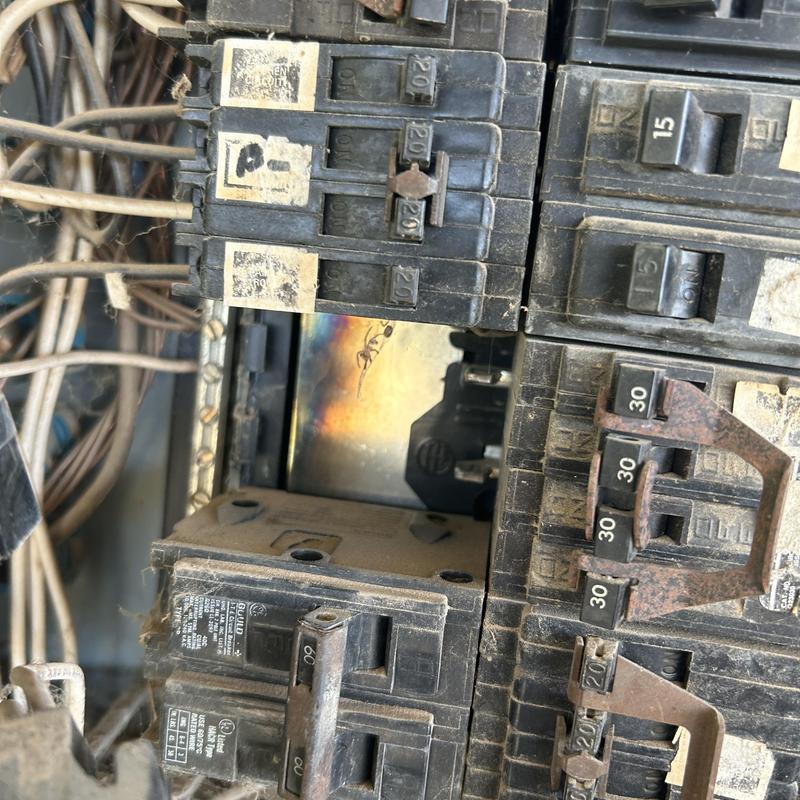 Main electrical panel with burnt breaker and corrosion