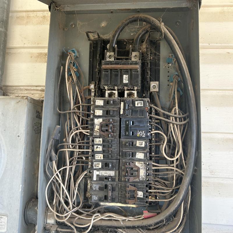 Main electrical panel with corroded breakers and wiring