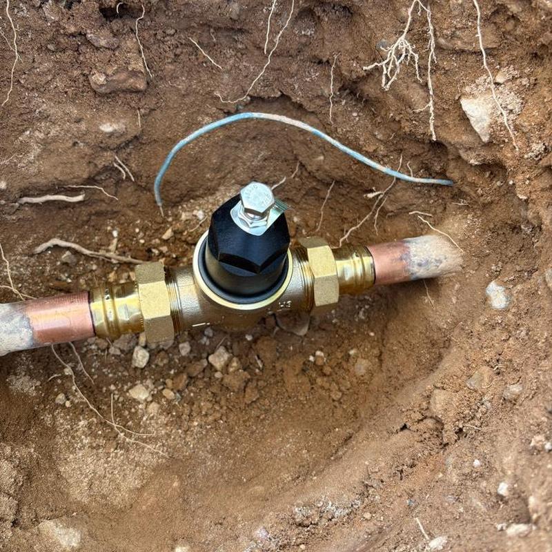 One inch pressure relief valve installed in ground with copper piping
