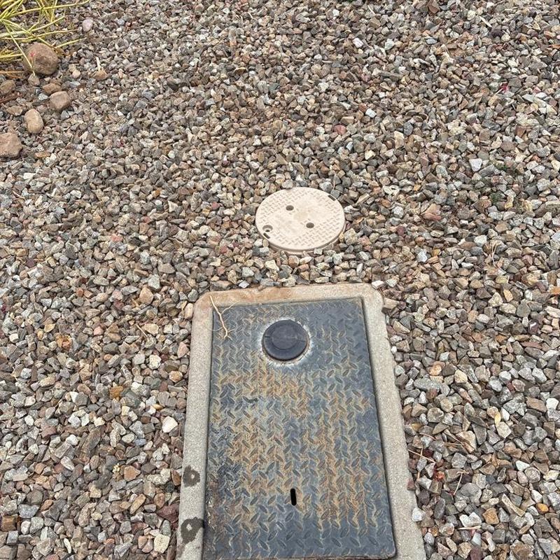 Water main access box and surrounding gravel ground