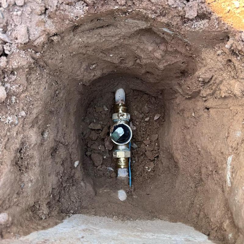 Copper water main with pressure regulator valve in dirt hole