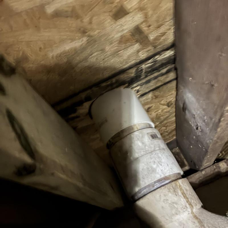 PVC drain pipe connection under wooden floor joists