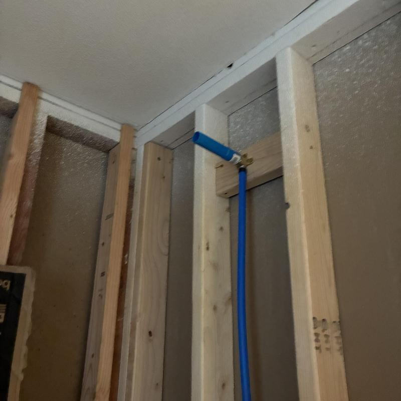 Blue PEX tubing installed with wood framing supports