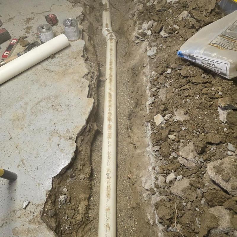 Laundry stack PVC pipe replacement in concrete floor trench
