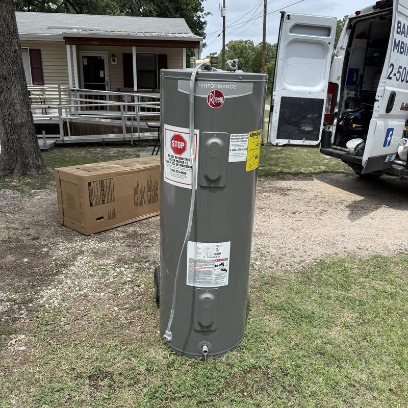 Water heater tank outdoors near work van and house