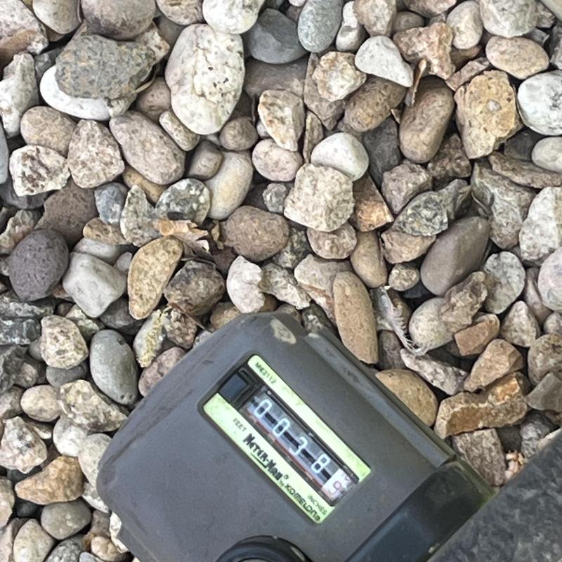 Water meter on gravel with usage reading visible