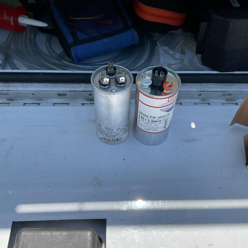 Dual run capacitors side by side on white surface
