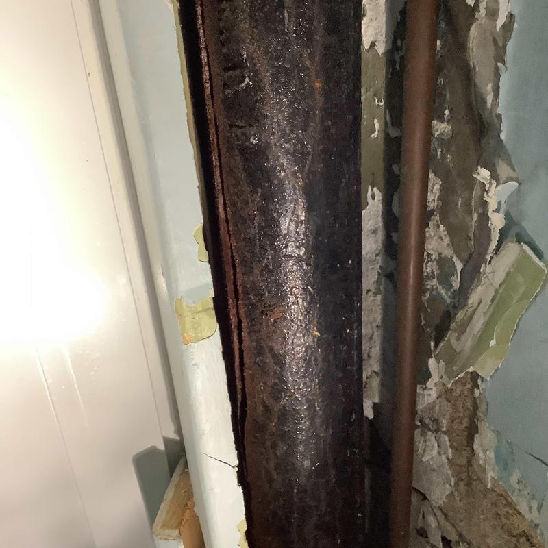 Cast iron drain pipe with wall damage in home Cast iron drain pipe with wall damage in home