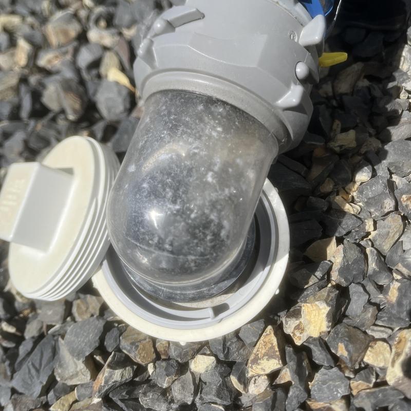 RV waste outlet with specialty pump-out adapter on gravel