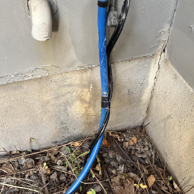 Water filtration system blue tubing near foundation wall