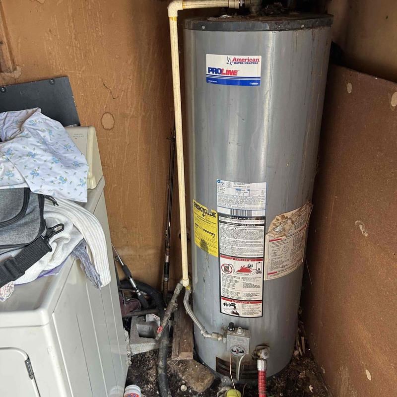 Water heater unit in utility room with plumbing